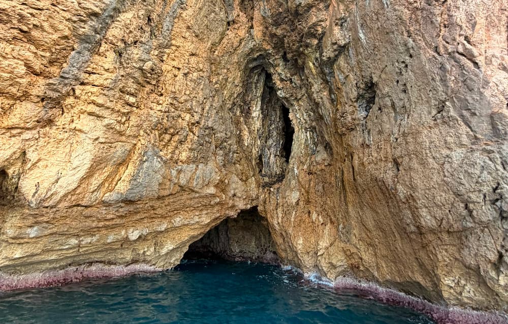 Entrada de una cueva marina entre acantilados rocosos de la Costa Blanca.